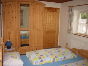 Schlafzimmer mit einem Bett und einem Holzschrank in der Unterkunft Familien-Bauernhof-Berghammer in Rottach-Egern