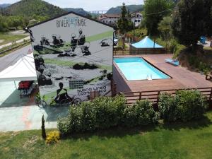 a large sign next to a swimming pool at River Tribe Experience Camp in Laino Borgo