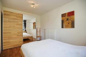 - une chambre avec un lit blanc et une porte en bois dans l'établissement Feriendorf Papillon Wohnung 03-2, à Boltenhagen