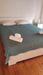 a bed with two rolls of towels on it at M.J.P. House in Metamorfosi