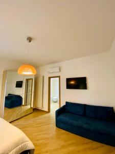 a living room with a blue couch and a bed at Villa Francesca in Spoltore