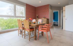 - une salle à manger avec une table et des chaises en bois dans l'établissement Tribord, appt avec terrasse et vue mer, parking, à Saint-Côme-de-Fresné
