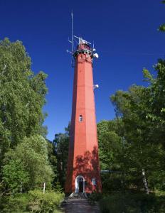 a tall red lighthouse sitting in a park at Apartament - Leśna Apart in Hel