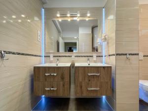 a bathroom with two sinks and a large mirror at Asbóth Taylor Apartment in Budapest