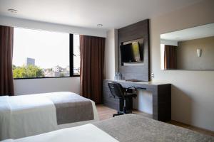 Hotel Brasilia tesisinde bir odada yatak veya yataklar