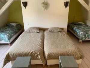a bedroom with two beds and two tables at SUPERBE TRIPLEX MEUBLÉ TOUT CONFORT HYPER CENTRE ST CÉRÉ 3 CHAMBRES WIFI 120 M2 8 pers max in Saint-Céré