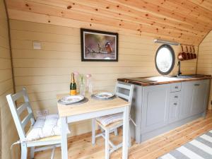 a kitchen with a table and chairs in a cabin at Willow Pod in Arundel
