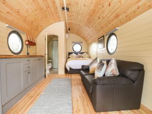 a bedroom with a couch and a bed in a room at Filbert Pod in Arundel