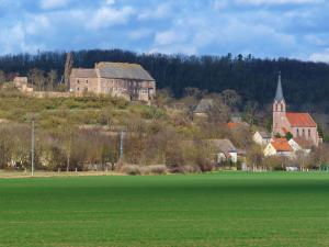 a large green field in front of a town with a church at Apartment in Gerbstedt Friedeburg with Terrace in Friedeburg