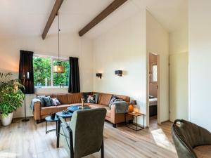 uma sala de estar com um sofá e uma mesa em Cosy holiday home in the countryside em Hellendoorn