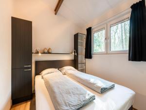 een slaapkamer met een bed en een raam bij Cosy holiday home in the countryside in Hellendoorn