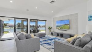 a living room with two couches and a tv at FLOATING ON THE CANALS - 80 COMMODORE CRES in Port Macquarie