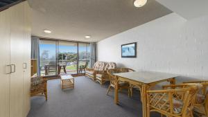 a living room with a table and chairs at 15 Beachpark Apartments in Port Macquarie