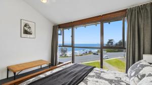 a bedroom with a bed and a large window at 15 Beachpark Apartments in Port Macquarie
