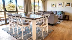 a living room with a dining room table and chairs at Perfectly Positioned Beachfront Apartment - Unit 6 in Port Macquarie