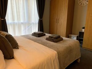 a bedroom with a bed with two towels on it at Modern Cosy Warm Home With Free Parking in Chelmsford