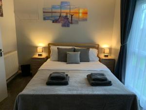 a bedroom with a bed with two towels on it at Modern Cosy Warm Home With Free Parking in Chelmsford