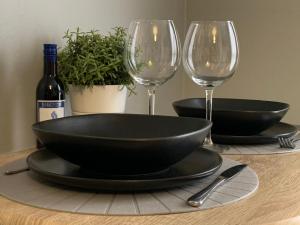 uma mesa com dois copos de vinho vazios e uma taça em Modern Cosy Warm Home With Free Parking em Chelmsford