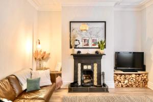 a living room with a couch and a fireplace at Sea Retreats, Whitley Bay, Sleeps 8 in Whitley Bay