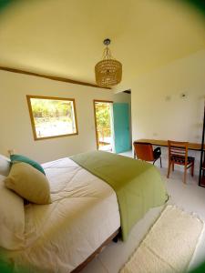 um quarto com uma cama, uma mesa e cadeiras em Suítes Manjuba Praia de Sta Tereza em Ilhabela