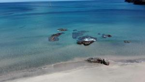 an aerial view of a beach with rocks in the water at Alo Baía São Lourenço in Santa Bárbara