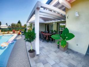 pergola na patio ze stołem i basenem w obiekcie Villa Calla w mieście Soiano del Lago