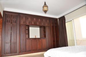 アガディールにあるLovely Marina Flatの鏡付きの木製の壁のベッドルーム