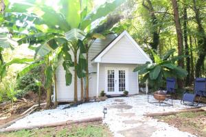 a small white house in the middle of a forest at Modern Tiny House Experience in Stone Mountain