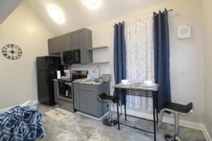 a small kitchen with a sink and a counter with stools at Modern Tiny House Experience in Stone Mountain