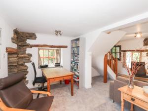 a living room with a table and a chair at Cherry Tree Cottage at Satterthwaite in Hawkshead