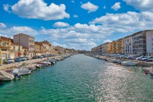 rzeka z łodziami w mieście z budynkami w obiekcie Five to Sete w mieście Sète