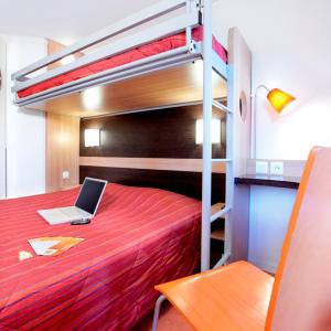 ein Schlafzimmer mit einem Etagenbett und einem Laptop darauf in der Unterkunft Premiere Classe Valenciennes Sud - Rouvignies in Valenciennes