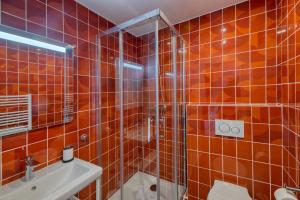 ein Badezimmer mit orangefarben gefliesten Wänden und einer Dusche in der Unterkunft Five to Sete - Gare - Centre-ville in Sète + 43 Fotos