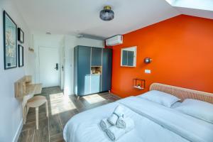 a bedroom with an orange wall and a bed at Five to Sete - Gare - Centre-ville in Sète
