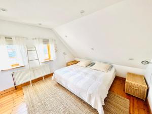 a white bedroom with a bed and a window at Authentisches Inselhaus - ideal für Kiter/Surfer/Familien in Fehmarn