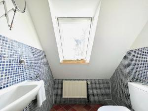 a bathroom with a sink toilet and a window at Authentisches Inselhaus - ideal für Kiter/Surfer/Familien in Fehmarn +16 photos