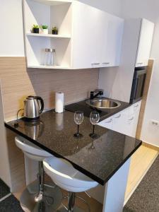 a kitchen with two wine glasses on a counter at FiORE self check-in in Osijek