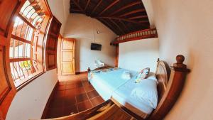 a bedroom with a bed in a room with a window at La Casa de las Flores Hostal in Jardin