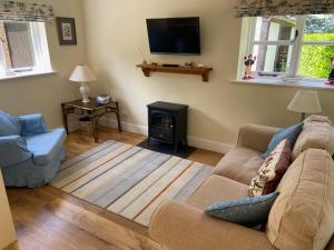 ein Wohnzimmer mit Couch und Kamin in der Unterkunft Oke Apple Cottage in Shillingstone + 3 Fotos