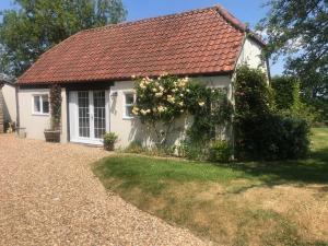 a white cottage with a red roof at Oke Apple Cottage in Shillingstone