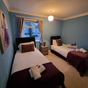 a bedroom with two beds and a window at PREMIER - Whifflet Apartment in Coatbridge +31 photos