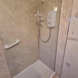 a bathroom with a shower with a glass door at PREMIER - Whifflet Apartment in Coatbridge