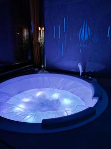 uma grande banheira de hidromassagem num quarto com iluminação azul em PentLux - SPA Penthouse in the heart of Skopje em Skopje