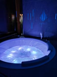 a large jacuzzi tub in a room with blue lighting at PentLux - SPA Penthouse in the heart of Skopje in Skopje
