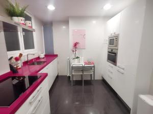 a kitchen with white cabinets and purple counter tops at Turquesa :) Parking and Wifi in Bilbao