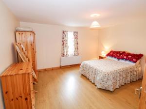 Schlafzimmer mit einem Bett und Holzboden in der Unterkunft At the Crossroads in Louisburgh