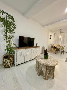 sala de estar con TV y mesa en A Das Marías ESTUDIO, en Ourense