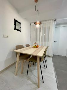 a dining room table with chairs and a light fixture at A Das Marías ESTUDIO in Ourense
