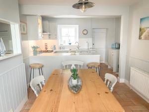 eine Küche mit einem Holztisch und Stühlen in der Unterkunft The Ferryman in Weymouth