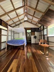 a bedroom with a hammock in the middle of a room at Pequeño Paraiso 2 in Punta Uva